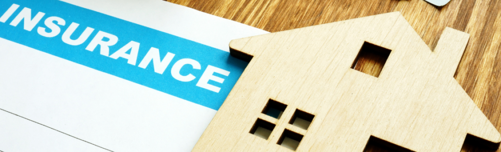 insurance paper with mini wood home on top