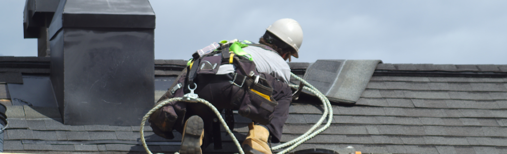roofer on roof fixing shingles