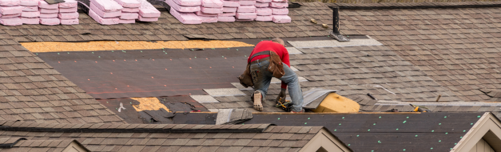 roofer laying shingles on roof