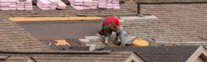 roofer laying shingles on roof