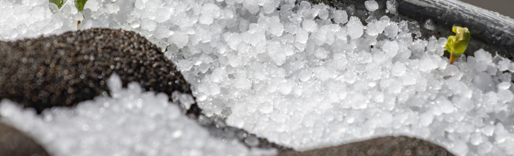 closeup of hail on shingle roof and gutters